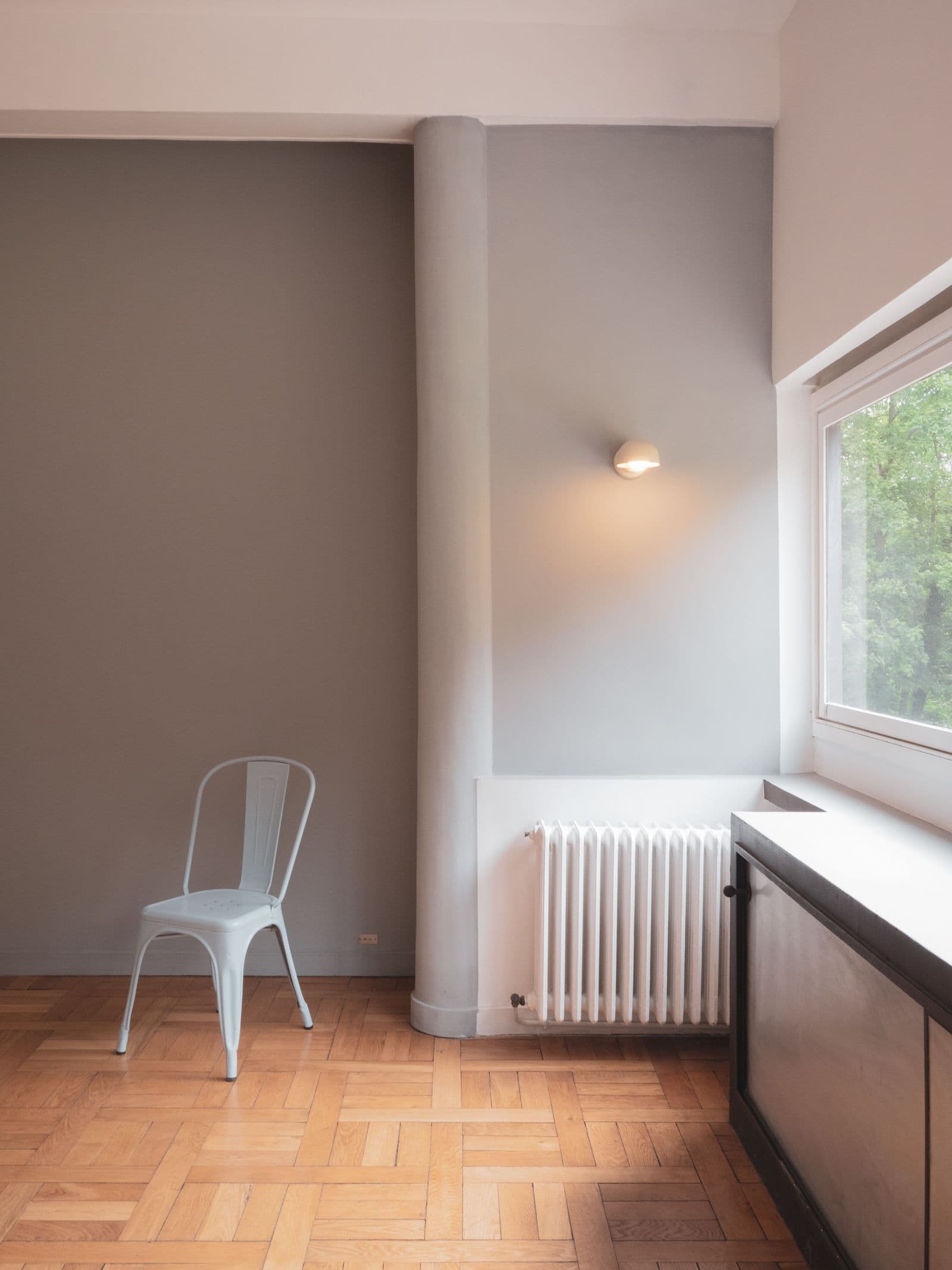 Intérieur d’appartement bruxellois lumineux, parquet ancien et grandes fenêtres